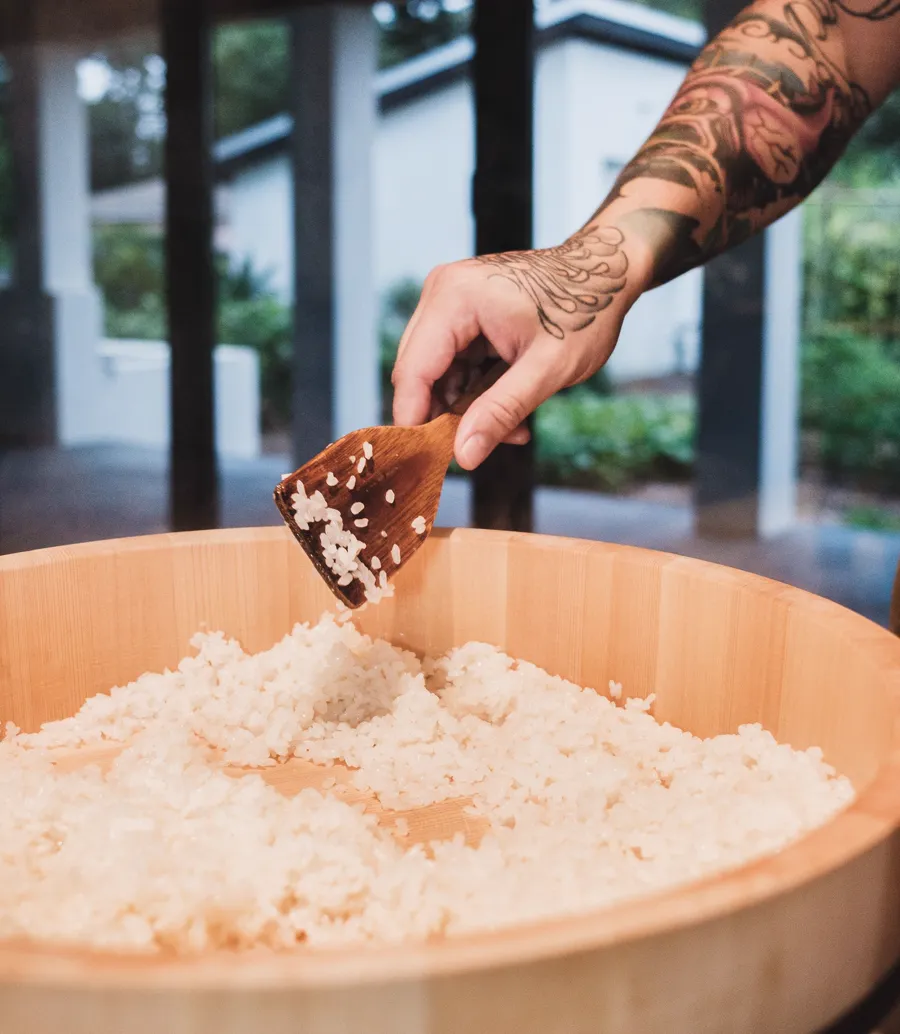 Pá de madeira a mexer o arroz no hangiri.