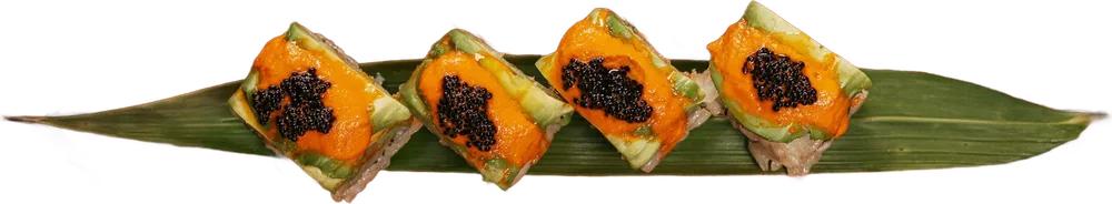 Oshizushi, sushi prensado em retângulos, com ovas por cima, sobre folha de bambu.
